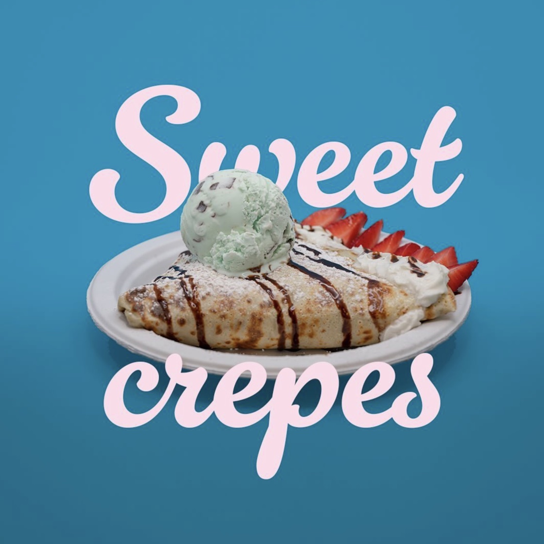 Sweet crepe topped with mint ice cream, strawberries and chocolate drizzle